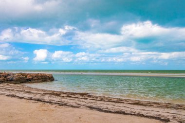Doğal manzara manzarası güzel Holbox adası kumsalı ve plajı dalgalar turkuvaz su ve mavi bulutlu gökyüzü Quintana Roo Mexico 'da.