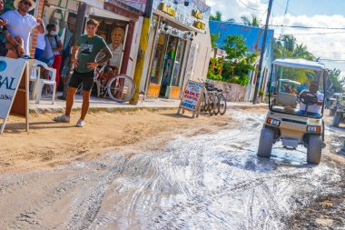 Holbox Meksika 22. Aralık 2021 'de Holbox Adası Meksika' da çamurlu bir sokakta golf arabası sürüyor..