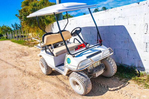 Тележки с тележками для гольфа на грязной улице в деревне на острове Холбокс в Мексике.