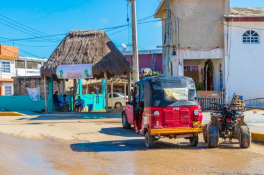Chiquil Mexico 21. December 2021 Red auto rickshaw tuk tuk in beautiful Chiquila village port harbor Puerto de Chiquil in Quintana Roo Mexico. clipart