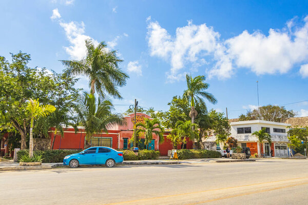 Tulum Mexico 02. February 2022 Driving thru typical colorful street road and cityscape with cars traffic palm trees bars and restaurants of Tulum in Mexico.