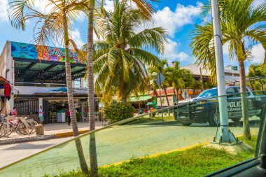 Tulum Meksika 02. Şubat 2022 Polis arabalı pikap, tipik renkli sokak yolu ve şehir manzarası üzerinden Meksika 'da Tulum' da palmiye ağaçları, barlar ve restoranlarla hızlı gidiyor..