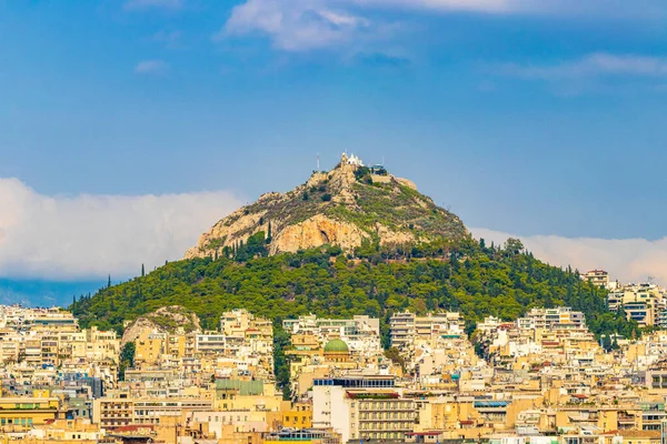 Likavittou Lykabettus ve Aziz Isidore Kilisesi Yunanistan 'ın başkenti Atina' da mavi bulutlu gökyüzü ile.