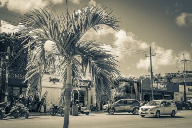 Tulum Meksika 02. Şubat 2022 Tipik sokak yolu ve şehir manzaralı siyah beyaz araba trafiği palmiye ağaçları ve Meksika 'da Tulum restoranları.