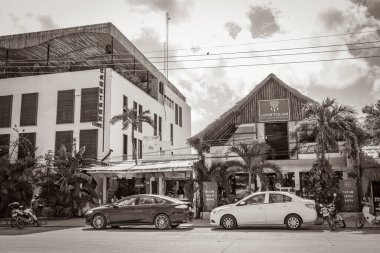 Tulum Meksika 02. Şubat 2022 Tipik sokak yolu ve şehir manzaralı siyah beyaz araba trafiği palmiye ağaçları ve Meksika 'da Tulum restoranları.