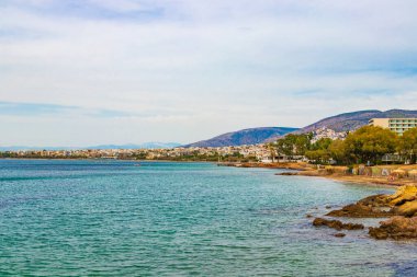 Yunanistan 'ın Voula kenti yakınlarındaki Vouliagmeni Sahili' nde doğal yeşil turkuaz plajı ve su.