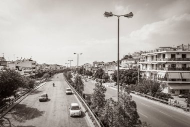 Yunanistan 'ın başkenti Atina' da tipik bir sokak yolunun eski siyah beyaz resmi arabalar ve palmiye ağaçları inşa ediyor.