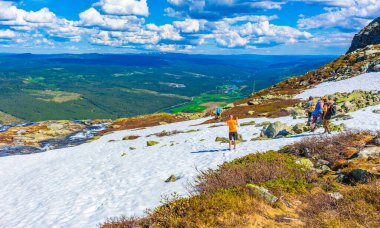 Hemsedal Norveç 06. Haziran 2016 'da Hydalen Hemsedal' ın güzel bir manzarası olan Norveç 'te yaz aylarında dağlarda kar yağarken, turistler ve fotoğrafçılar yürüyüş yolunda..