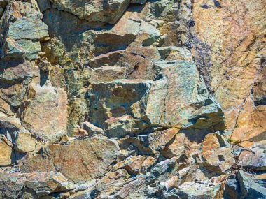 Hemsedal Norveç 'te turuncu ve sarı yosun ve liken renkleriyle taş duvar dokusu.