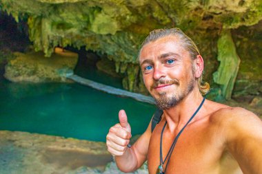 Gezgin ve turist rehberi, Puerto Aventuras Quintana Roo Mexico 'daki Santuario de los guerreros' taki muhteşem mavi turkuaz suyu ve kireçtaşı mağarası çukurunda..