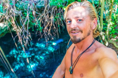 Porto Aventuras Quintana Roo Mexico 'da Tajma ha Tajmaha adlı inanılmaz mavi turkuaz suyu ve kireçtaşı mağarası turist rehberi..