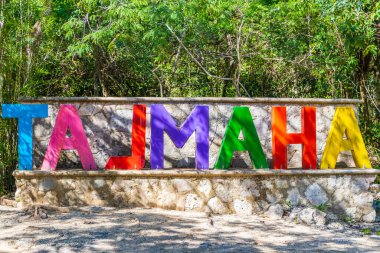 Quintana Roo Meksika 04. Şubat 2022 'de, Puerto Aventuras Quintana Roo Mexico' daki muhteşem mavi turkuaz su ve kireçtaşı mağarası subatanı Tajma ha Tajmaha 'nın yazı tipi sembolü heykeli..
