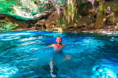 Porto Aventuras Quintana Roo Mexico 'da Tajma ha Tajmaha adlı inanılmaz mavi turkuaz suyu ve kireçtaşı mağarası turist rehberi..