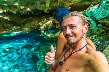 Muhteşem mavi turkuaz su ve kireçtaşı mağara çukurunda bikinili genç ve seksi kadın modeller Puerto Aventuras Quintana Roo Mexico 'da Tajma ha Tajmaha' yı sahneliyor..