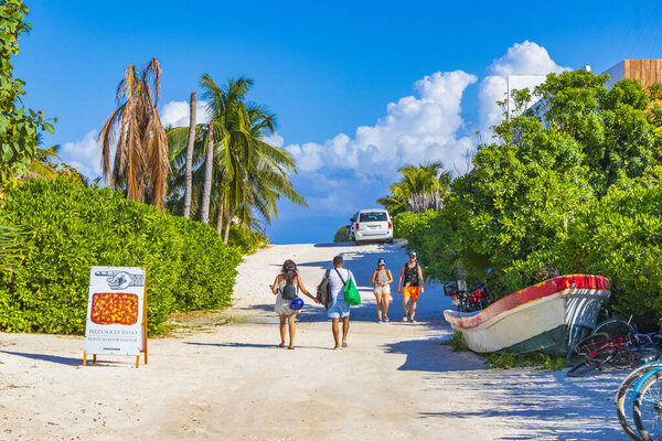 Tulum Mexico 02. February 2022 Sandy way path entrance to the amazing and beautiful caribbean coast and beach with panorama view turquoise water people and parked cars of Tulum in Quintana Roo Mexico.