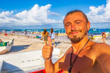 Mutlu model turist ve gezgin, Quintana Roo Mexico 'daki Turkuaz su insanları ve Tulum kulübeleriyle Karayip sahilleri ve sahil manzarasına gülümsüyor..