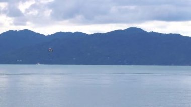 Koh Samui adasında tekneleri ve jet ski ile Tayland 'daki Koh Pha-ngan manzaralı Bo Phut Plajı.