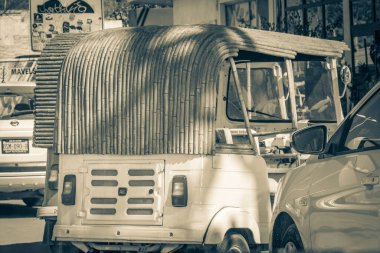 Tulum Meksika 02. Şubat 2022 Tipik renkli sokak yolu ve şehir manzarası boyunca araba sürüşünün eski siyah beyaz resmi. Tuk tuk arabaları, palmiye ağaçları, Meksika 'da Tulum restoranları ve barları..