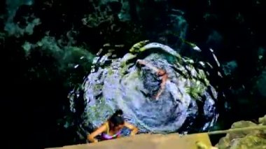 Young sexy couple lady pretty woman models with bikini in amazing blue turquoise water and limestone cave sinkhole cenote Tajma ha Tajmaha in Puerto Aventuras Quintana Roo Mexico.