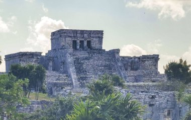 Antik Tulum, Tulum Meksika 'daki tropikal doğal orman palmiyesi ve deniz manzarasında tapınak kalıntıları ve eserlerle Maya bölgesini harabeye çeviriyor..