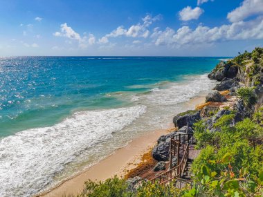 Antik Tulum, Tulum Meksika 'daki tropikal doğal orman palmiyesi ve deniz manzarasında tapınak kalıntıları ve eserlerle Maya bölgesini harabeye çeviriyor..