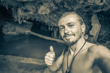 Gezgin ve turist rehberinin Puerto Aventuras Quintana Roo Mexico 'daki Santuario de los guerreros' taki muhteşem mavi turkuaz suyu ve kireçtaşı mağara çukurundaki eski siyah beyaz resmi..