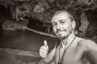 Gezgin ve turist rehberinin Puerto Aventuras Quintana Roo Mexico 'daki Santuario de los guerreros' taki muhteşem mavi turkuaz suyu ve kireçtaşı mağara çukurundaki eski siyah beyaz resmi..