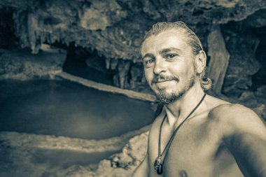 Gezgin ve turist rehberinin Puerto Aventuras Quintana Roo Mexico 'daki Santuario de los guerreros' taki muhteşem mavi turkuaz suyu ve kireçtaşı mağara çukurundaki eski siyah beyaz resmi..