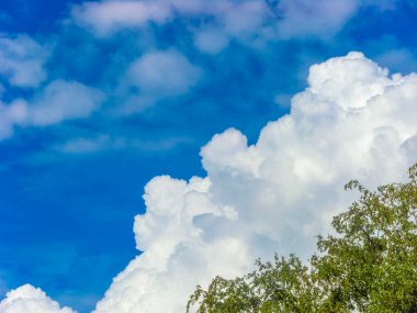 Beyaz bulutlu mavi gökyüzü güzel bulutlar ve Bremerhaven Almanya 'sında arka planda ağaçlar.