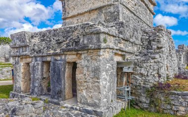 Antik Tulum, Tulum Meksika 'daki tropikal doğal orman palmiyesi ve deniz manzarasında tapınak kalıntıları ve eserlerle Maya bölgesini harabeye çeviriyor..