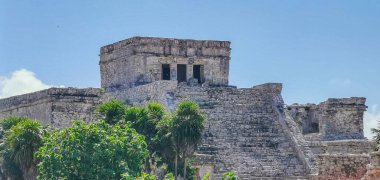 Antik Tulum, Tulum Meksika 'daki tropikal doğal orman palmiyesi ve deniz manzarasında tapınak kalıntıları ve eserlerle Maya bölgesini harabeye çeviriyor..