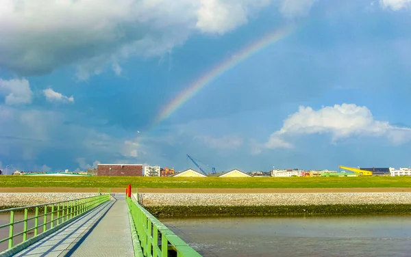 Cityscape rainbow and coast panorama of ATLANTIC Hotel Sail City lighthouse architecture ships boats dike and landscape of Bremerhaven in Germany.