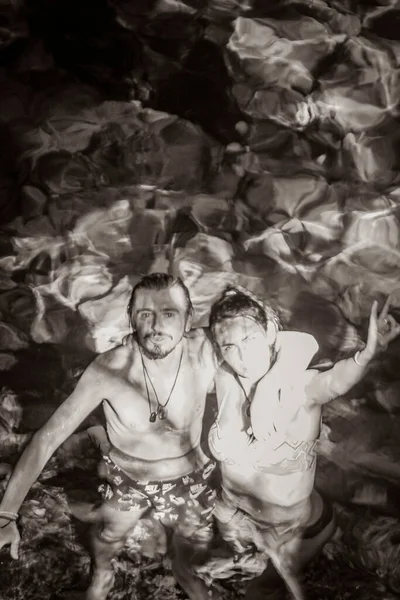 Old black and white picture of Young sexy couple lady pretty woman models with bikini in amazing blue turquoise water and limestone cave sinkhole cenote Tajma ha Tajmaha in Quintana Roo Mexico.