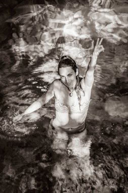 Puerto Aventuras Quintana Roo Mexico 'daki Tajma ha Tajmaha' nın muhteşem mavi turkuaz su ve kireçtaşı mağara çukurunda bikinili seksi kadın modelinin eski siyah beyaz resmi..