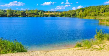 Güzel taş ocağı gölü tarama gölü mavi turkuvaz su gökyüzü ve manzara doğa ormanı manzarası Eggestedt Schwanewede Osterholz Aşağı Saksonya Almanya 'sı.