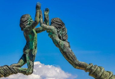 The ancient architecture of the Portal Maya in the Fundadores park with blue sky and turquoise seascape and beach panorama in Playa del Carmen Quintana Roo Mexico.