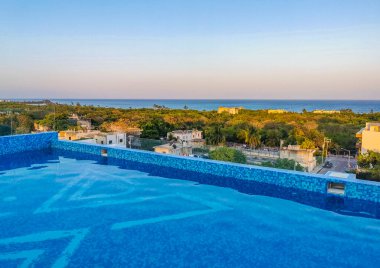 Amazing sunset sunrise and night cityscape landscape and caribbean ocean and beach panorama view at infinity pool on rooftop in Playa del Carmen in Quintana Roo Mexico.