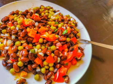 Vegetable dish soup with beans peas potatoes onions tomato and garlic on a white plate bowl with fork or spoon in Mexico.