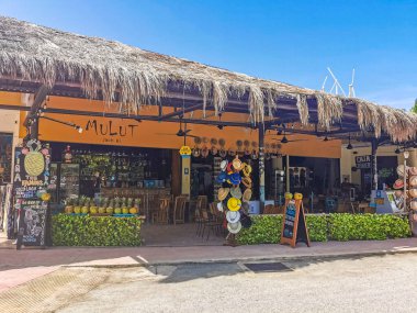 Tulum Mexico 22. june 2022 Typical colorful street road and cityscape with cars traffic palm tourism shops bars and restaurants of Tulum in Mexico.