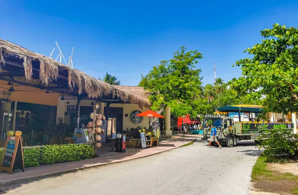 Tulum Mexico 22. june 2022 Typical colorful street road and cityscape with cars traffic palm tourism shops bars and restaurants of Tulum in Mexico.