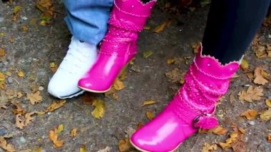 Pink boots and cool sneakers nervous woman Man wiggle his feet sitting on a bench.