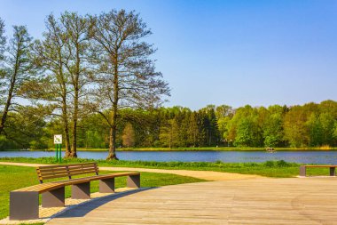 Natural beautiful panorama view with lake river walking pathway and green plants trees in the forest of Speckenbuetteler Park in Lehe Bremerhaven Germany.
