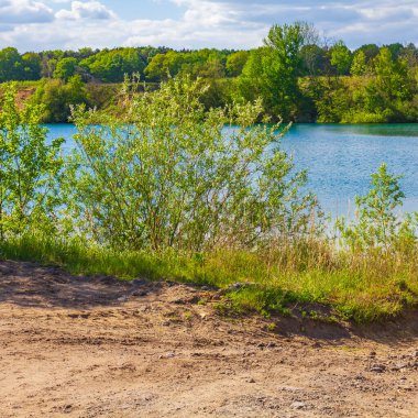 Güzel taş ocağı gölü tarama gölü mavi turkuvaz su gökyüzü ve manzara doğa ormanı manzarası Eggestedt Schwanewede Osterholz Aşağı Saksonya Almanya 'sı.