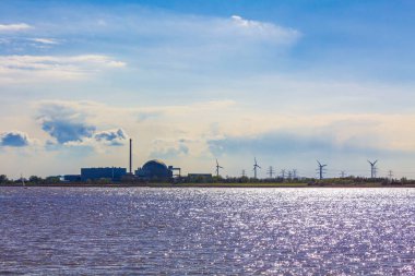 Atomic nuclear power station at the beautiful wadden sea tidelands coast beach water and dike landscape panorama at the Wesertunnel in Stadland Wesermarsch Lower Saxony Germany.
