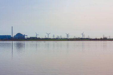 Atomic nuclear power station at the beautiful wadden sea tidelands coast beach water and dike landscape panorama at the Wesertunnel in Stadland Wesermarsch Lower Saxony Germany.