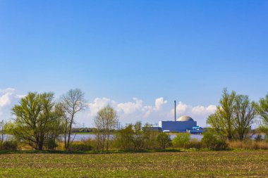 Atomic nuclear power station at the beautiful wadden sea tidelands coast beach water and dike landscape panorama at the Wesertunnel in Stadland Wesermarsch Lower Saxony Germany.