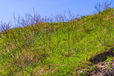 Excavated sand mountains and rubble piles quarry lake dredging pond lake with blue sky and landscape nature forest panorama view in Eggestedt Schwanewede Osterholz Lower Saxony Germany.