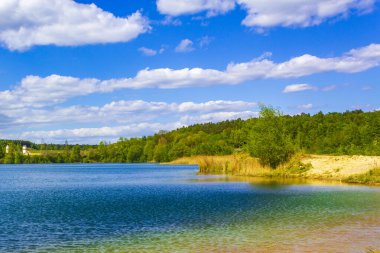 Güzel taş ocağı gölü tarama gölü mavi turkuvaz su gökyüzü ve manzara doğa ormanı manzarası Eggestedt Schwanewede Osterholz Aşağı Saksonya Almanya 'sı.