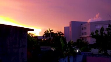 Amazing beautiful golden yellow pink purple blue and violet colorful sunrise sunset with sunbeams at tropical palm tree panorama view in Playa del Carmen Quintana Roo Mexico.