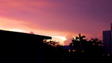 Amazing beautiful golden yellow pink purple blue and violet colorful sunrise sunset with sunbeams at tropical palm tree panorama view in Playa del Carmen Quintana Roo Mexico.